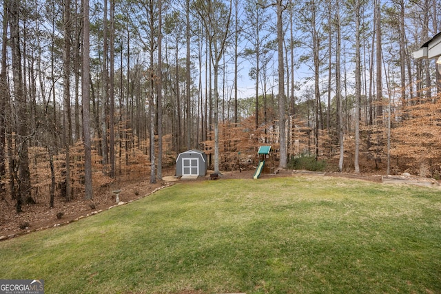 view of yard featuring a playground and a shed