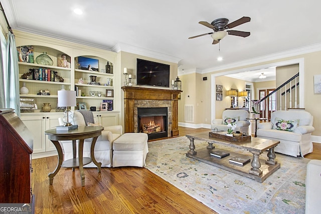 living room with ornamental molding, hardwood / wood-style floors, and a fireplace