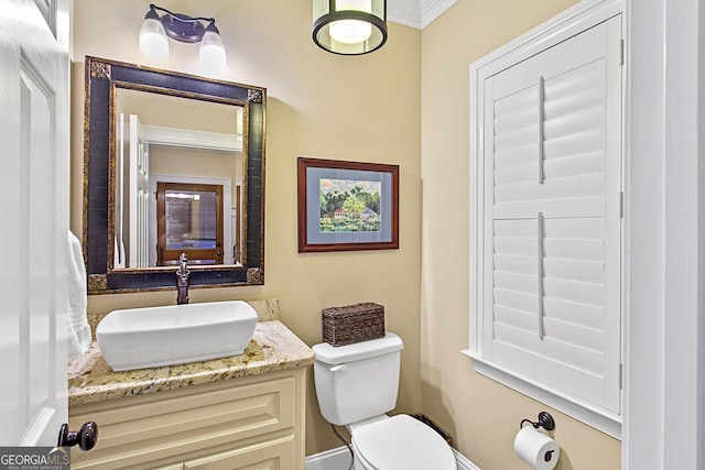 bathroom featuring vanity, ornamental molding, and toilet