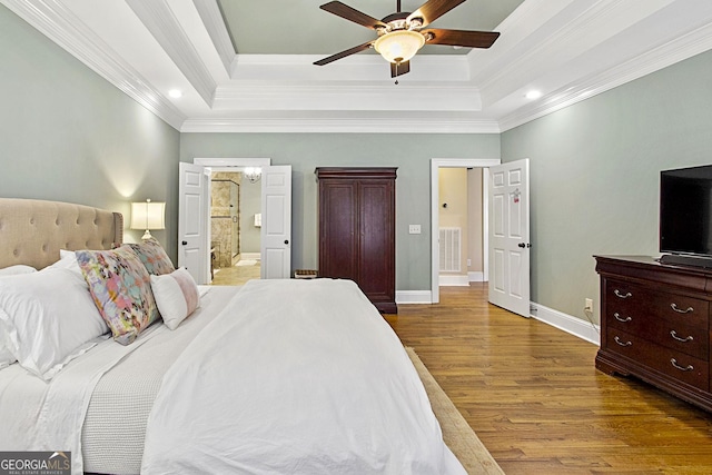 bedroom with a raised ceiling, ornamental molding, hardwood / wood-style floors, and ceiling fan