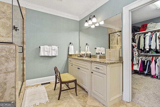 bathroom featuring vanity, tile patterned flooring, a shower with shower door, and ornamental molding