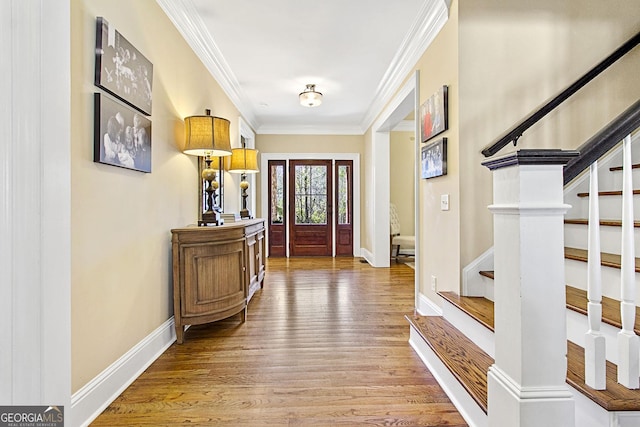 entryway with hardwood / wood-style flooring and crown molding