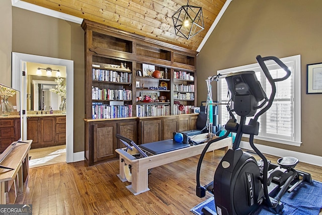 workout room featuring vaulted ceiling, built in features, wood-type flooring, crown molding, and wooden ceiling