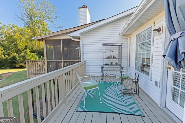 wooden deck featuring a sunroom and a yard