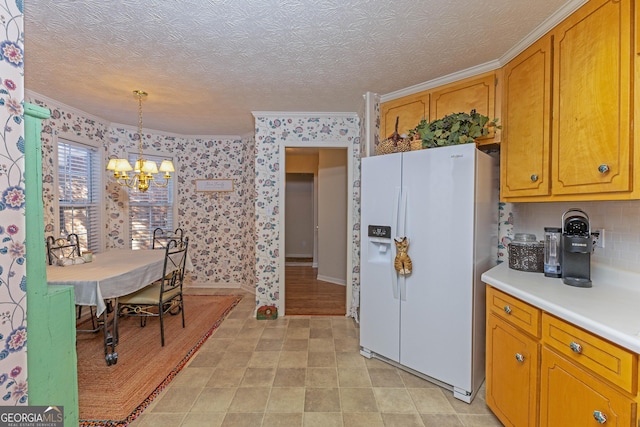 kitchen with ornamental molding, white refrigerator with ice dispenser, pendant lighting, and a textured ceiling