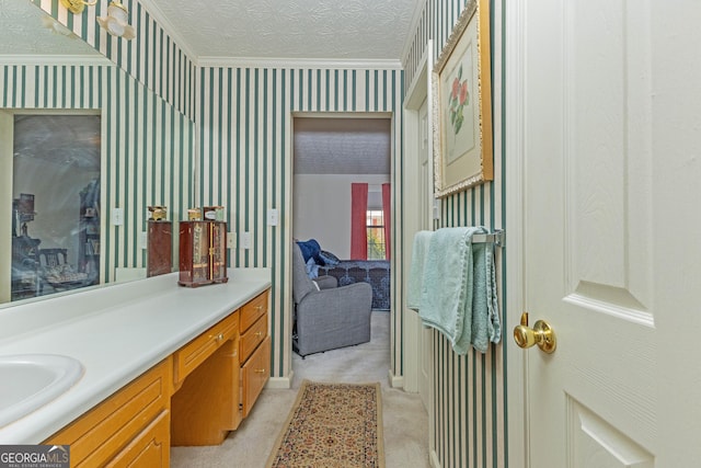 bathroom featuring vanity, ornamental molding, and a textured ceiling