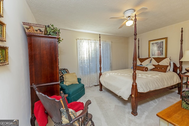 carpeted bedroom featuring ceiling fan and a textured ceiling