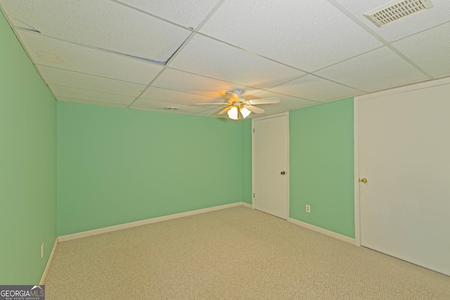 carpeted spare room featuring a paneled ceiling and ceiling fan