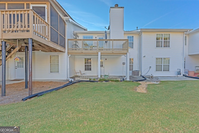 rear view of house with cooling unit, a lawn, a sunroom, and a patio