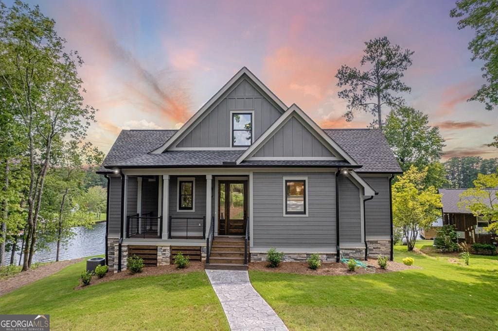 view of front of house with central AC and a lawn