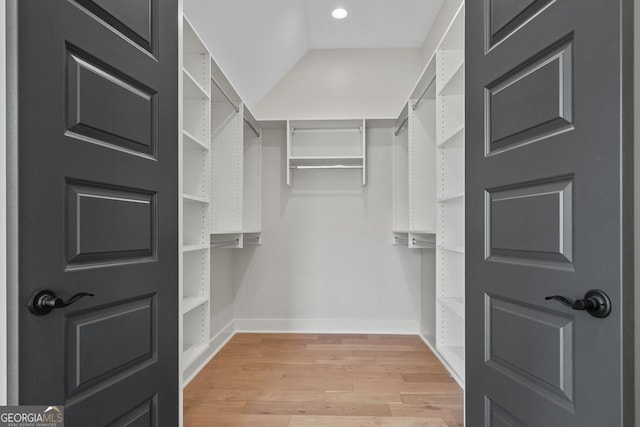 walk in closet featuring lofted ceiling and light hardwood / wood-style floors