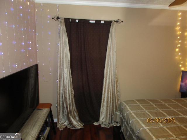 bedroom with ornamental molding and hardwood / wood-style floors