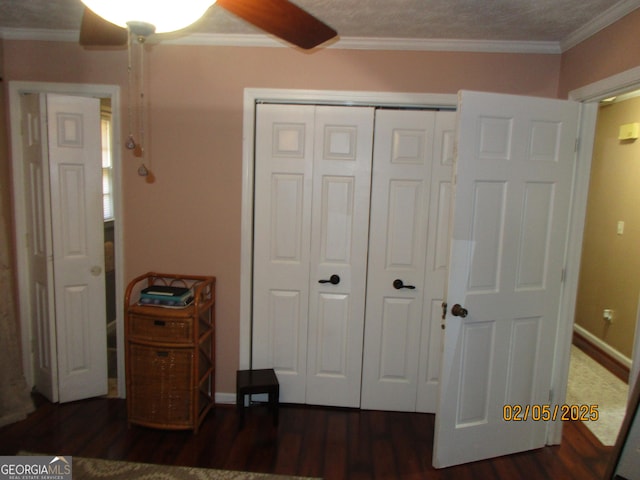 bedroom with crown molding, dark hardwood / wood-style floors, ceiling fan, and a closet