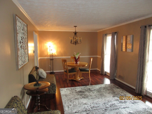 dining room with a notable chandelier, crown molding, dark hardwood / wood-style floors, and a textured ceiling