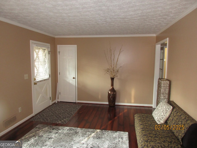 entryway with dark hardwood / wood-style flooring, ornamental molding, and a textured ceiling