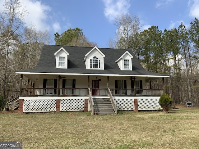 country-style home with ceiling fan, covered porch, and a front lawn