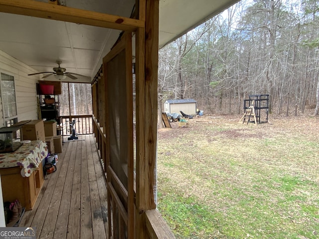 wooden deck featuring ceiling fan and a storage shed