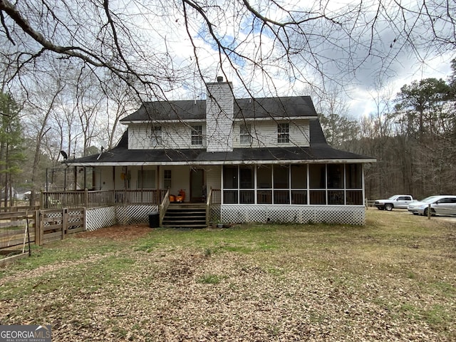 country-style home featuring a sunroom and a front lawn