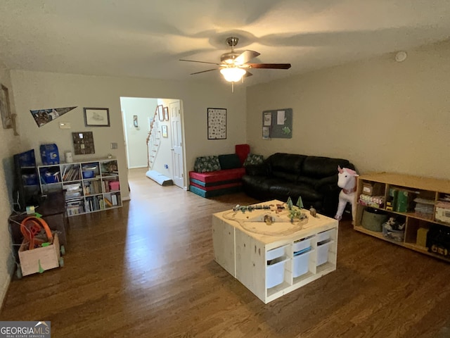 living room with ceiling fan and dark hardwood / wood-style floors