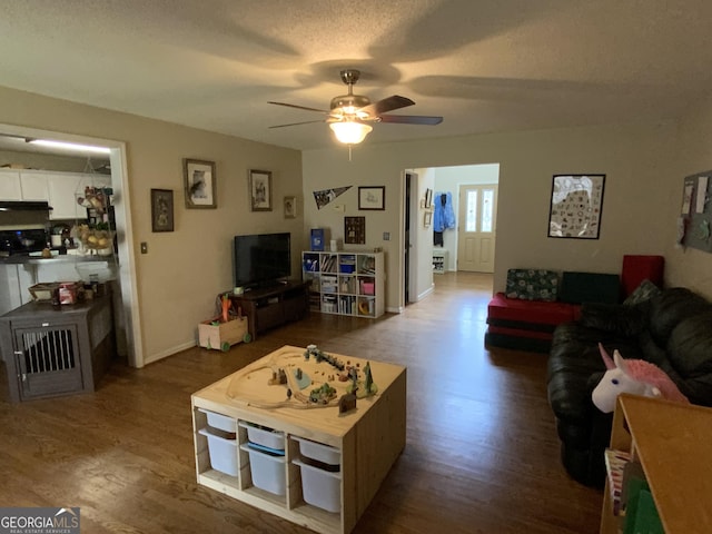 living room with hardwood / wood-style floors, a textured ceiling, and ceiling fan