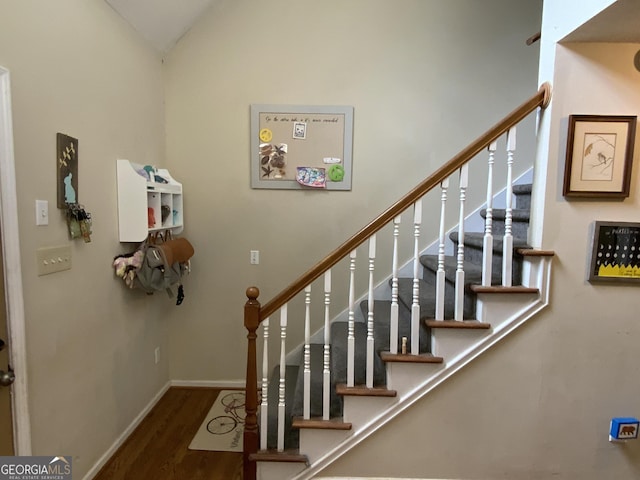 stairs featuring lofted ceiling and hardwood / wood-style floors