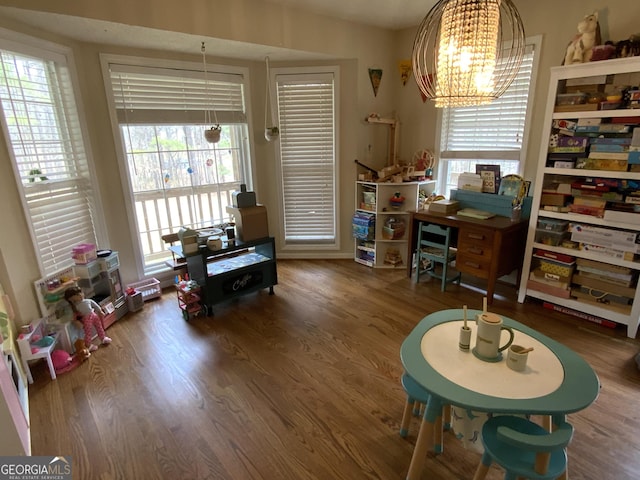 office with a notable chandelier, hardwood / wood-style flooring, and vaulted ceiling