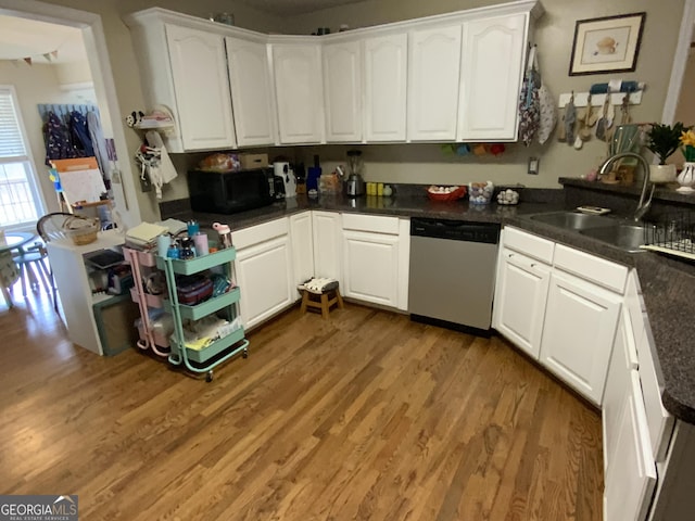 kitchen featuring dark hardwood / wood-style flooring, sink, stainless steel dishwasher, and white cabinets