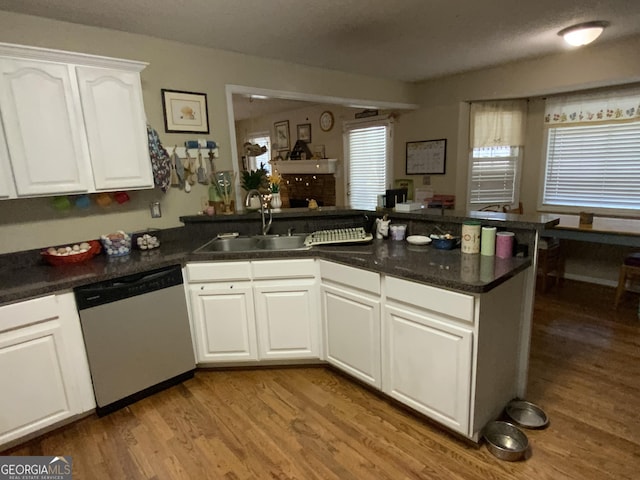 kitchen featuring sink, white cabinetry, light hardwood / wood-style flooring, dishwasher, and kitchen peninsula