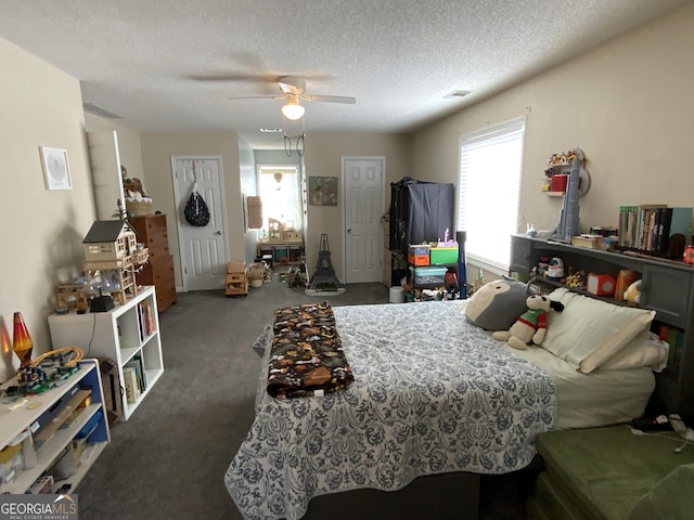 carpeted bedroom with ceiling fan and a textured ceiling