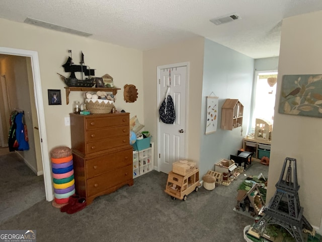 bedroom with a textured ceiling and dark colored carpet