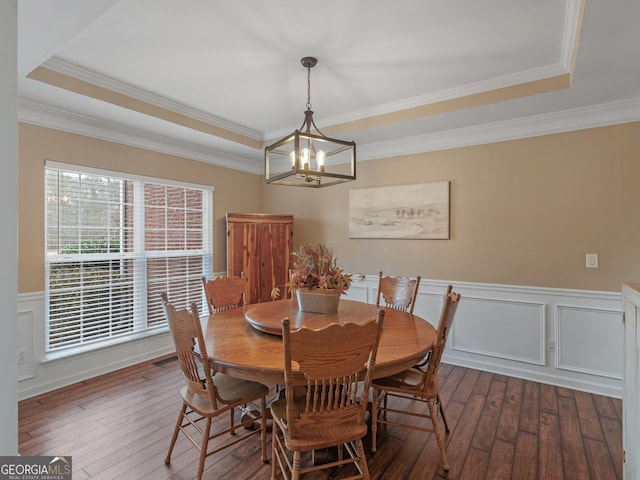 dining room with a raised ceiling, crown molding, dark hardwood / wood-style floors, and a notable chandelier