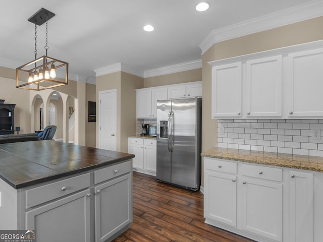 kitchen with white cabinetry, ornamental molding, pendant lighting, and stainless steel fridge with ice dispenser