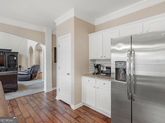 kitchen featuring stainless steel refrigerator with ice dispenser, crown molding, light stone counters, dark hardwood / wood-style flooring, and white cabinets