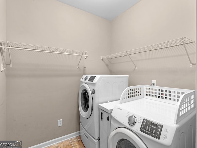 clothes washing area featuring washer and dryer and light tile patterned floors