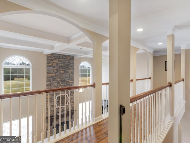 hall featuring coffered ceiling, hardwood / wood-style flooring, ornamental molding, and beamed ceiling