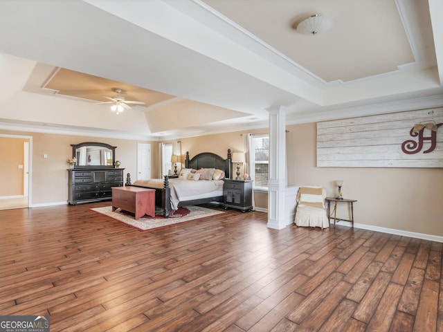 bedroom with crown molding, dark hardwood / wood-style flooring, a raised ceiling, and decorative columns