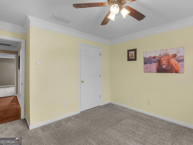 unfurnished bedroom featuring ceiling fan, ornamental molding, and carpet floors