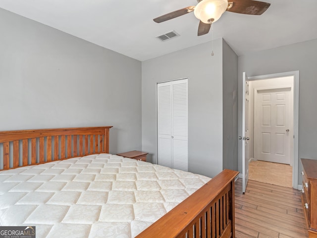 bedroom featuring light hardwood / wood-style flooring, ceiling fan, and a closet