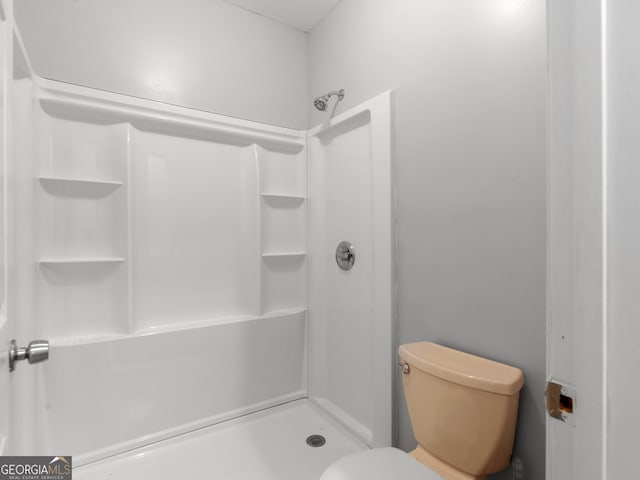 bathroom featuring toilet and walk in shower