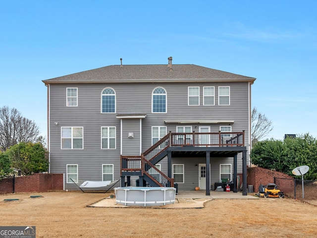 rear view of house with a swimming pool side deck, a yard, and a patio