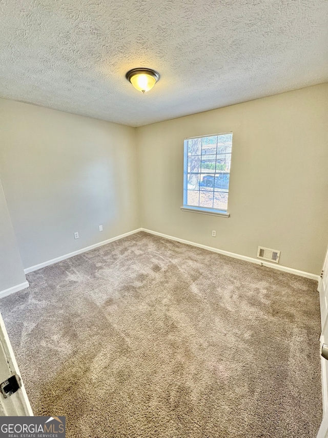 unfurnished room with carpet floors, baseboards, and visible vents