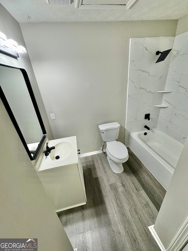 full bath featuring bathtub / shower combination, toilet, wood finished floors, vanity, and baseboards