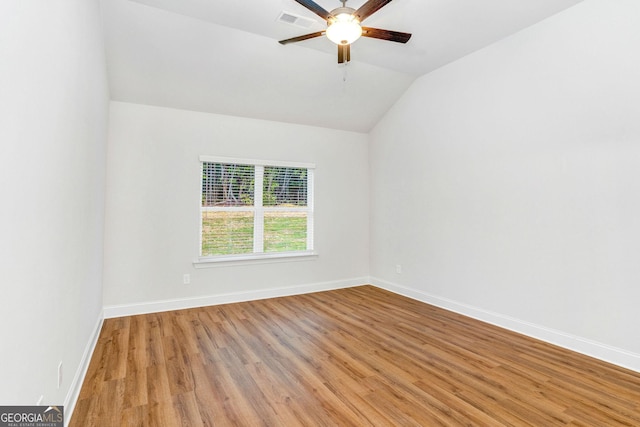 spare room with vaulted ceiling, ceiling fan, and light wood-type flooring