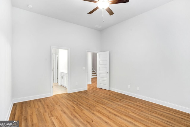 unfurnished bedroom with connected bathroom, ceiling fan, and light wood-type flooring