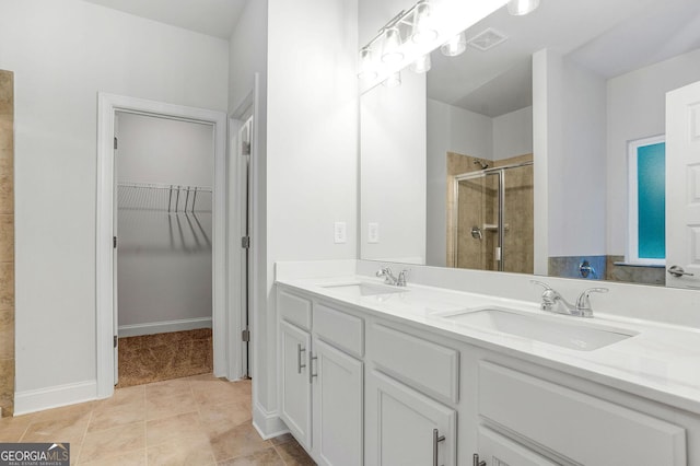 bathroom with vanity, tile patterned floors, and a shower with door