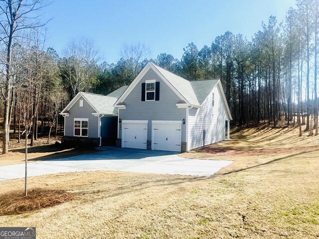 view of home's exterior with a garage and a lawn