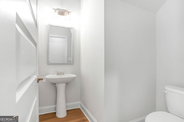 bathroom with hardwood / wood-style flooring, sink, and toilet