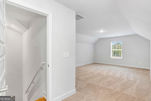 bonus room featuring vaulted ceiling and light carpet