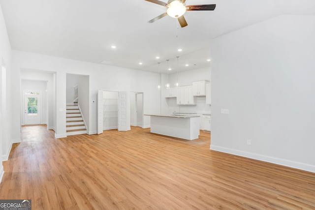 unfurnished living room featuring ceiling fan and light hardwood / wood-style floors