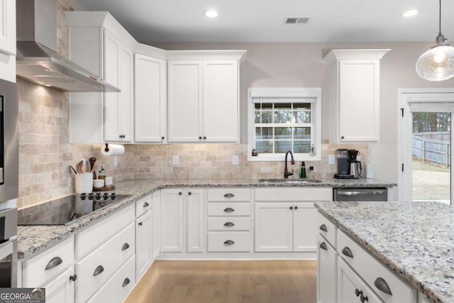 kitchen featuring white cabinetry, dishwasher, sink, and wall chimney range hood